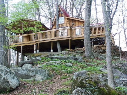 Log cabin with a wraparound deck in the woods