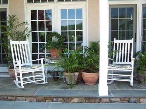 Front porch with white rocking chairs and potted plants